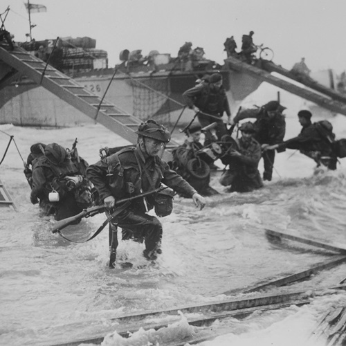 Black and White image showing Soldiers leaving their boats to fight on D-Day
