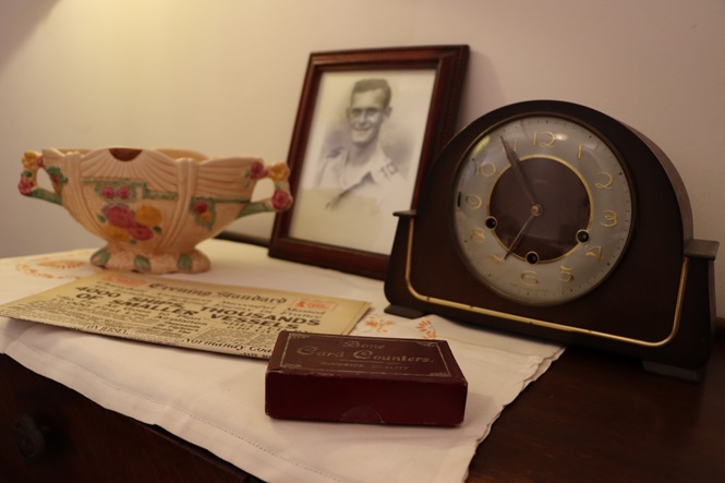 Image of 1940s clock and historic framed picture of serviceman during World War II