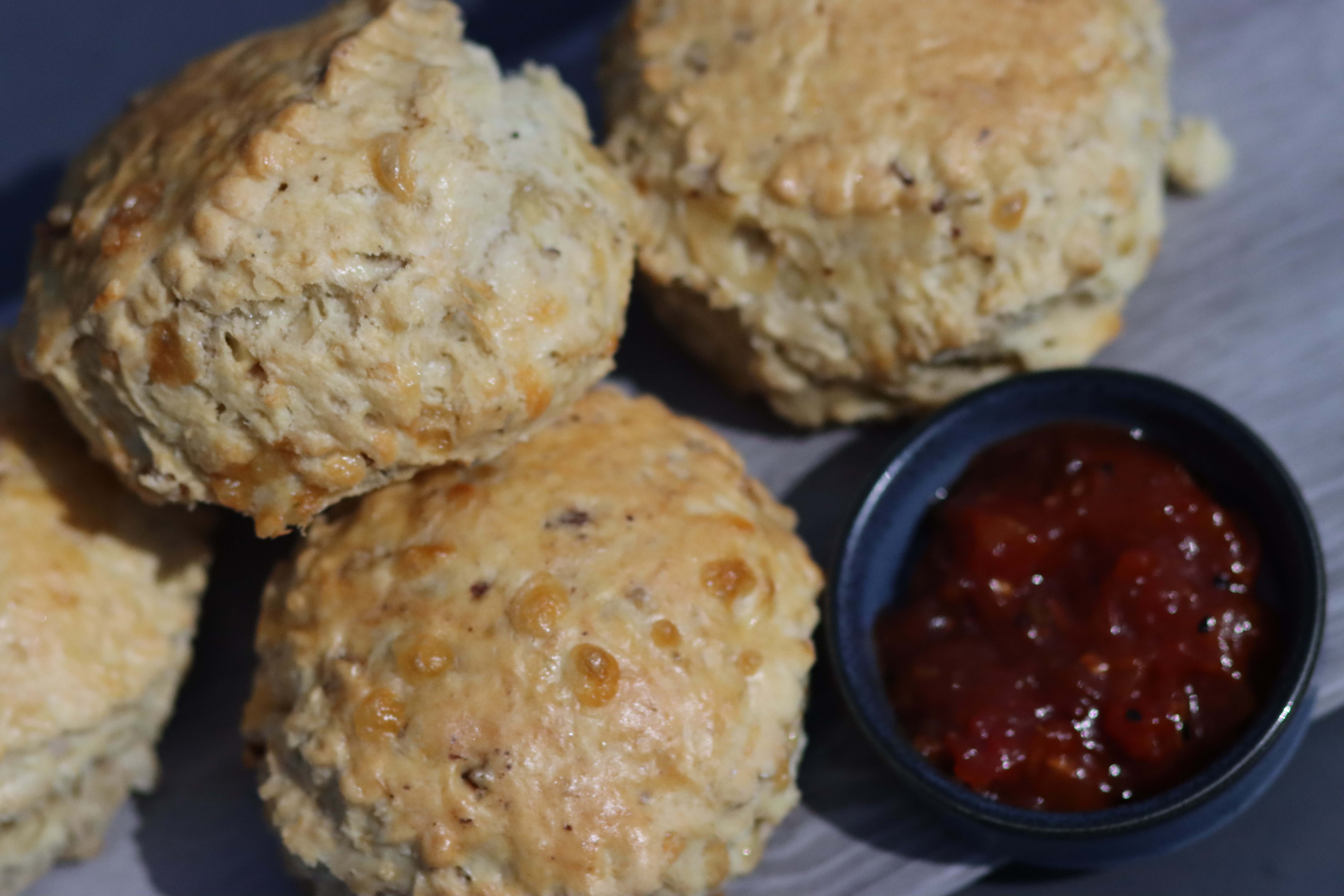 Freshly baked scones on a plate with red Jam