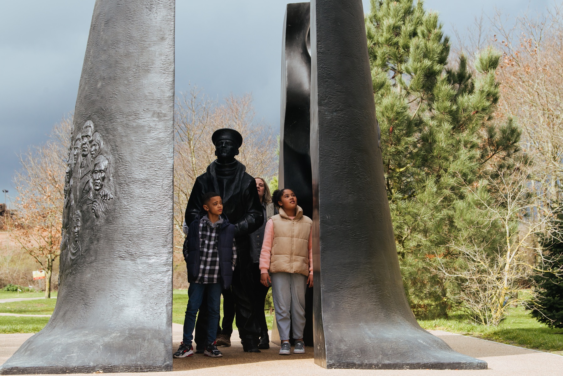 Two children walk through the centre of the Submariners Memorial