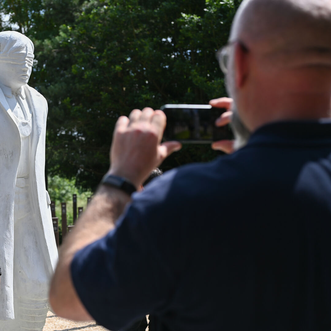 Visitor taking a photograph of the Shot at Dawn Memorial on his phone.